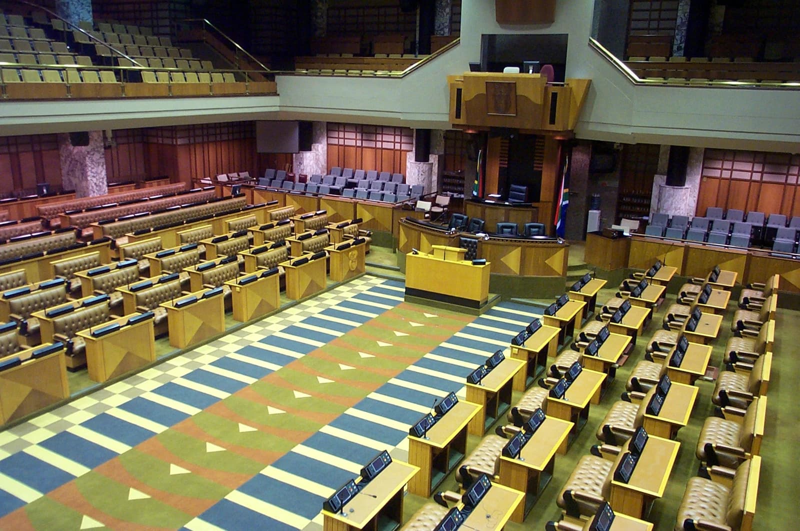 Interior of the South African National Assembly, showing empty seats and podiums.