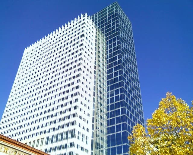 Target Plaza South Tower, a tall building with white and blue glass facades, under a blue sky.