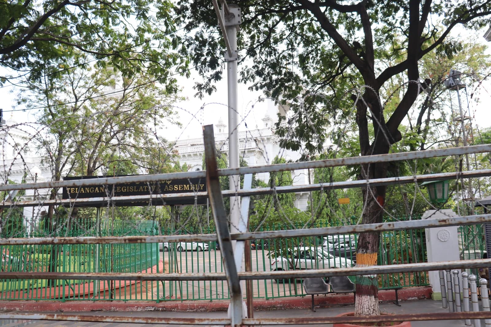 Exterior shot of the Telangana Legislative Assembly entrance, with security barriers in the foreground.