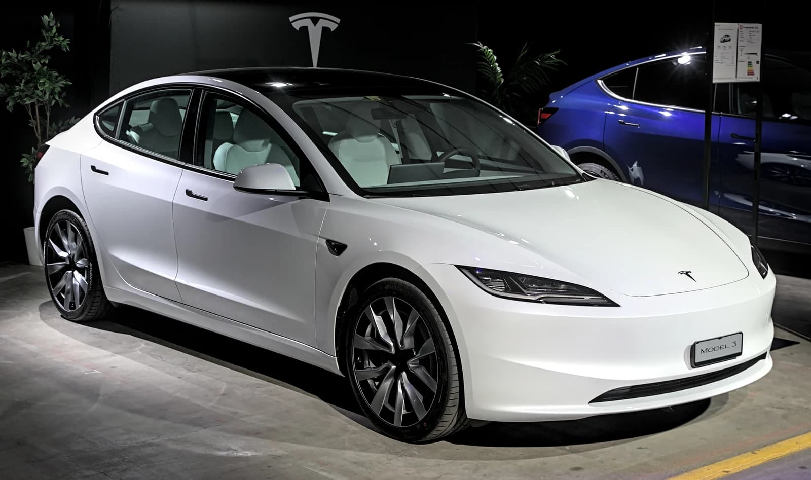 White Tesla Model 3 electric vehicle displayed at the Auto Zuerich 2023.