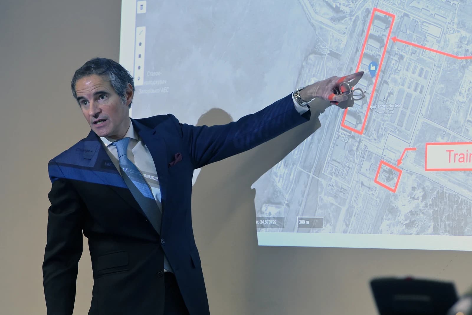 Rafael Grossi, Director General of the IAEA, pointing at a map during a press briefing.