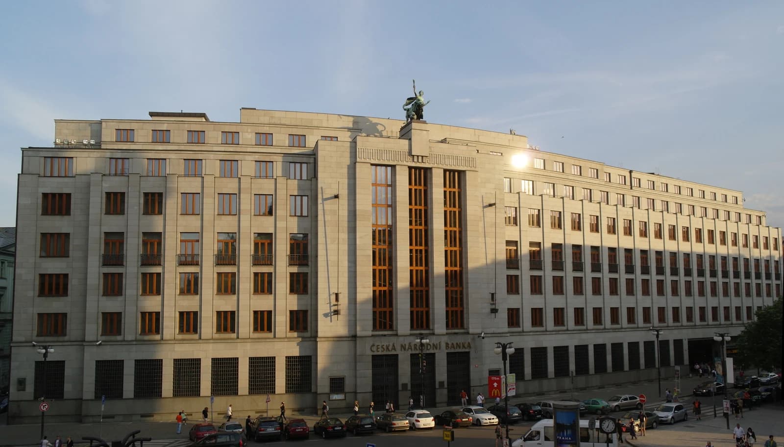 Building of the Czech National Bank, with cars and pedestrians on the street.