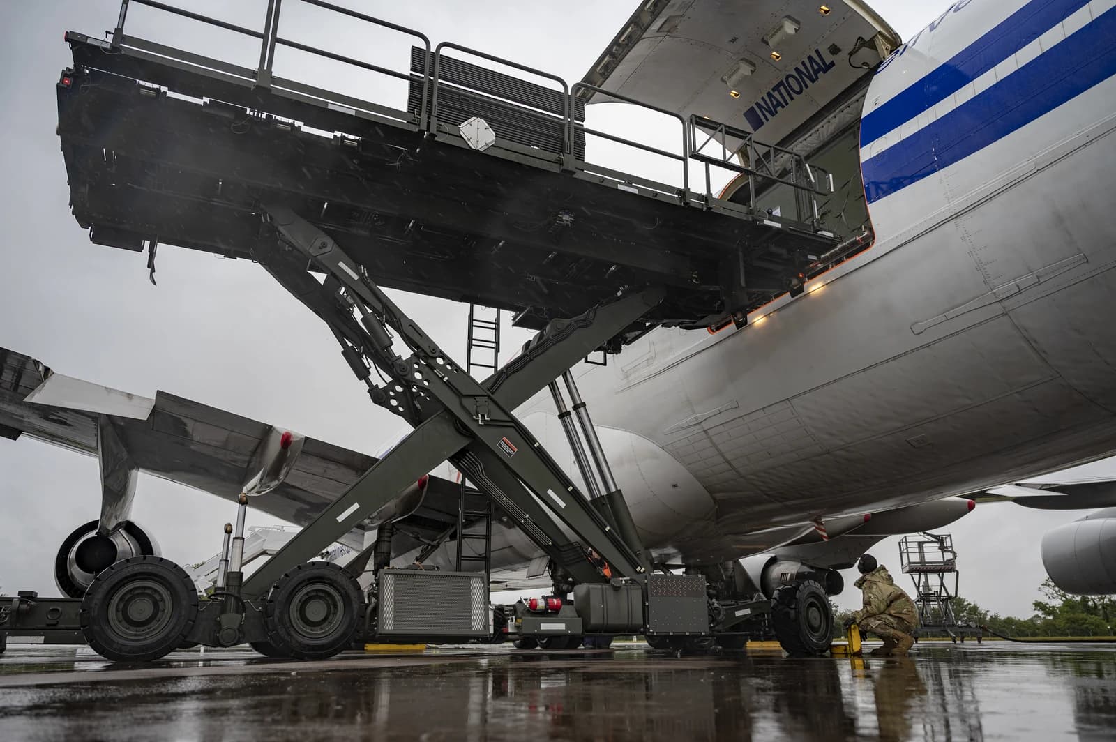 An airman loads cargo onto a large military transport aircraft at RAF Fairford.