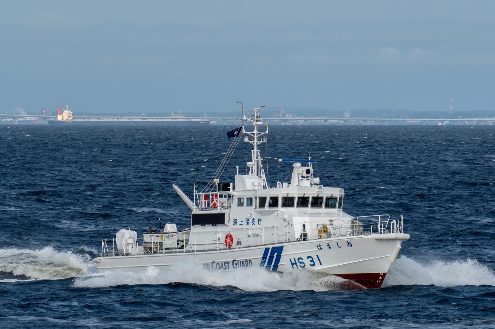 Japanese Coast Guard patrol boat HS-31 'Hamashio' navigates through blue water.