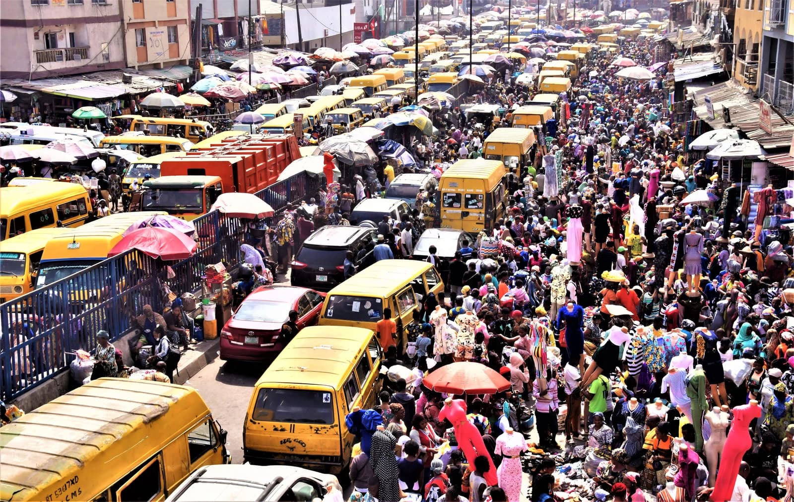 Overhead view of shoppers, vendors, and traffic at the busy Dumota Market in Lagos.