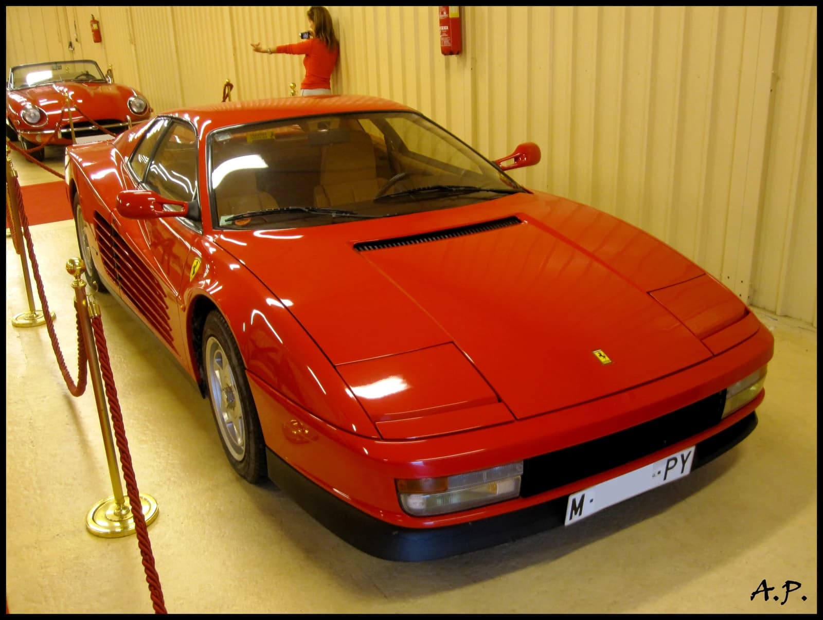 A red 1994 Ferrari Testarossa sports car parked indoors.