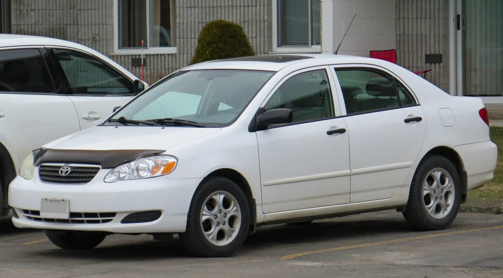 White 2006 Toyota Corolla CE Special Edition car with a sunroof, parked.