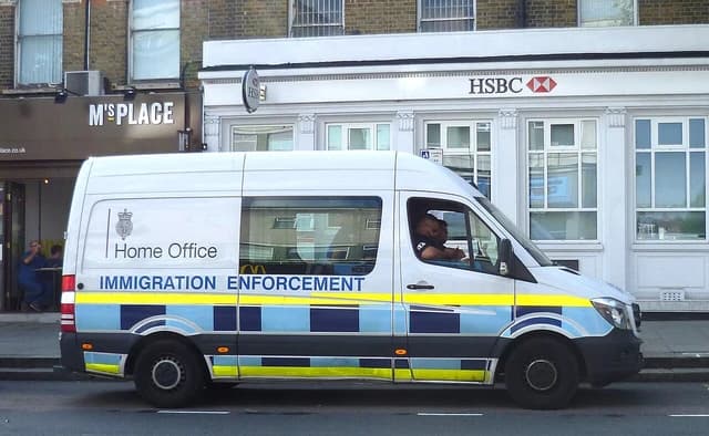 UK Home Office Immigration Enforcement vehicle parked outside a building.