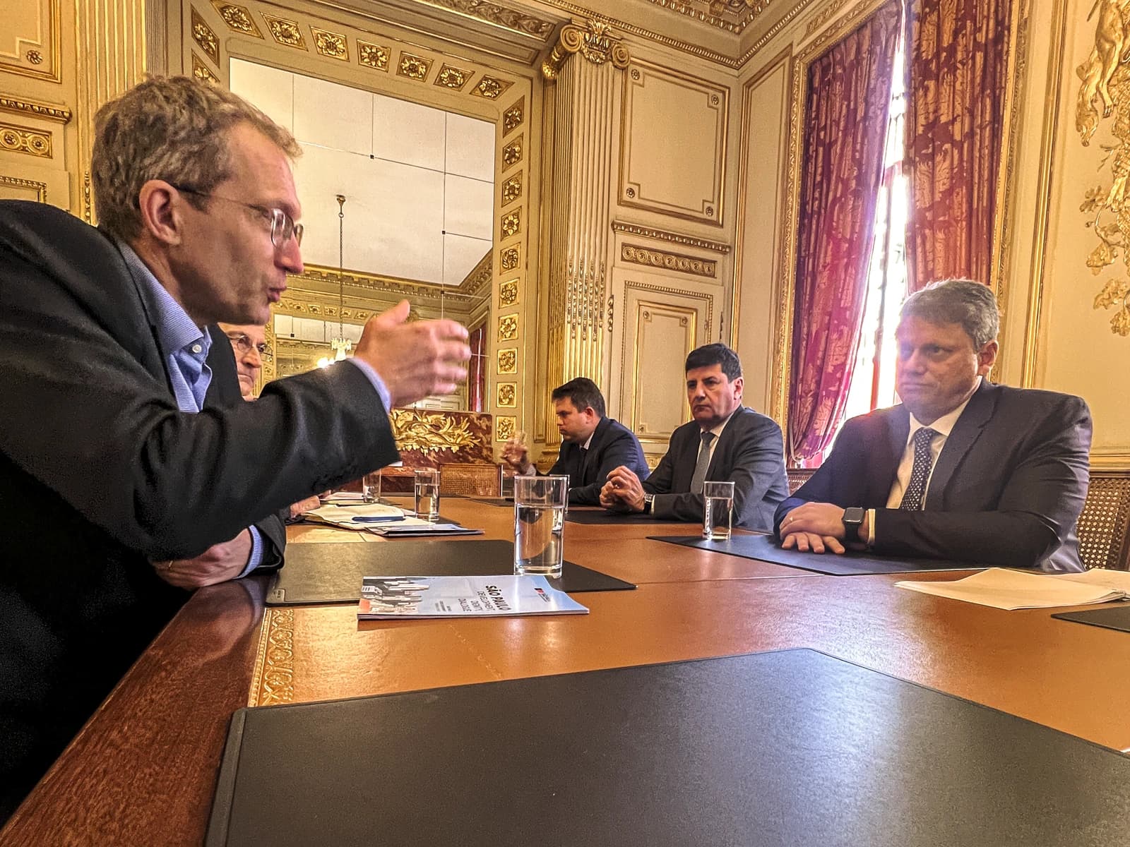 Henri Poupart-Lafarge, CEO of Alstom, speaking and gesturing at a meeting table.