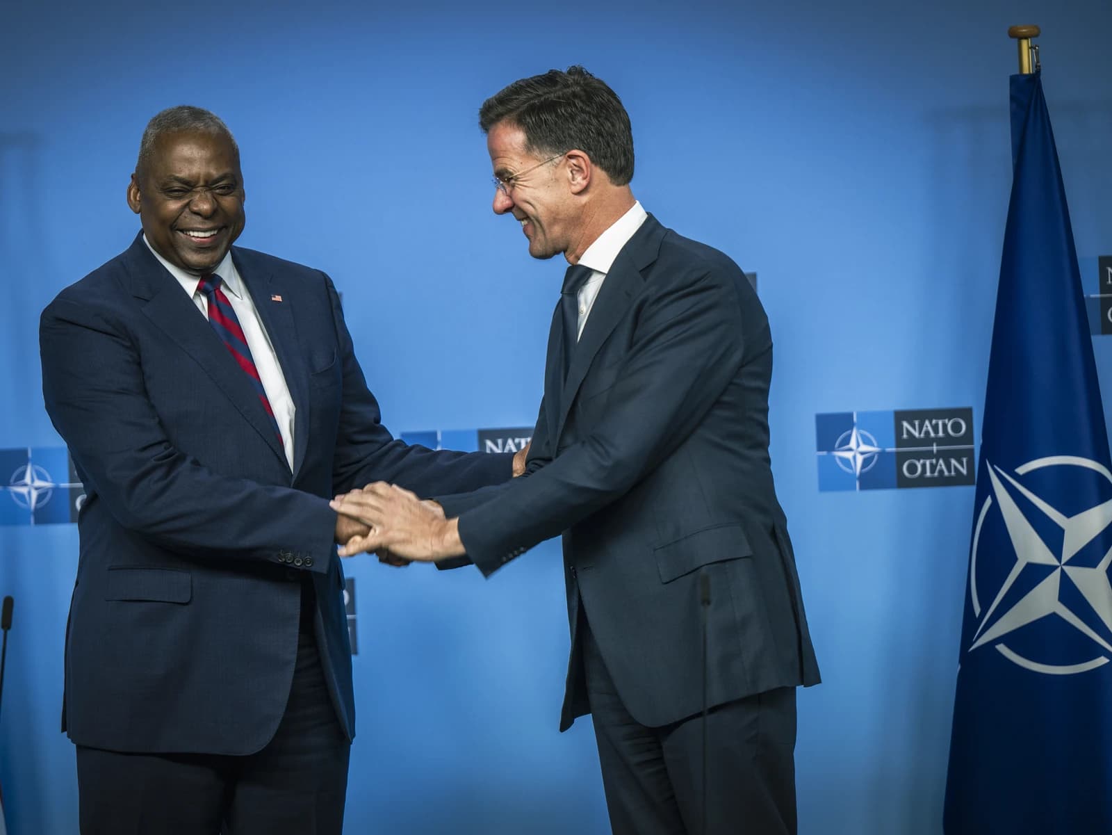 United States Secretary of Defense Lloyd Austin and NATO Secretary-General Mark Rutte shaking hands.