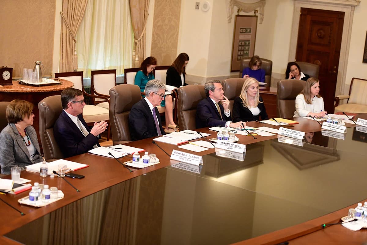 Federal Reserve governors, including Chairman Jerome Powell, attending a meeting around a conference table.