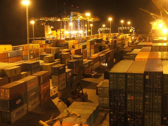 Shipping containers stacked at the Tema port in Ghana at night.
