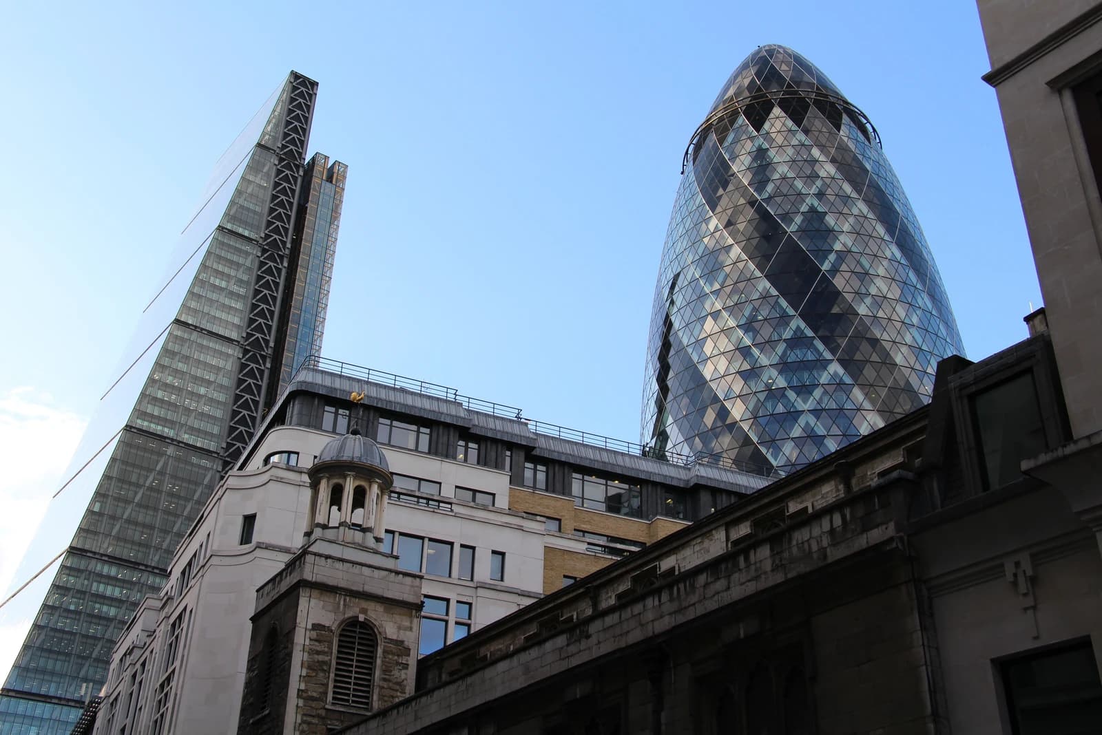 The Leadenhall Building and The Gherkin skyscrapers against a clear blue sky in London.