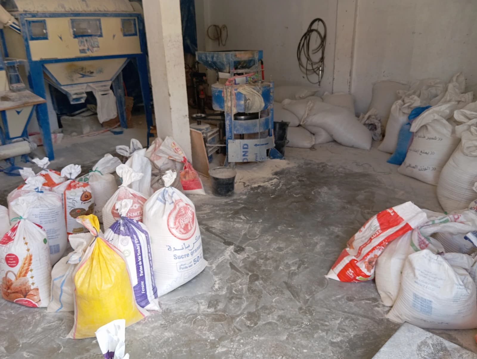 Sacks of flour and sugar inside a rural grain mill.