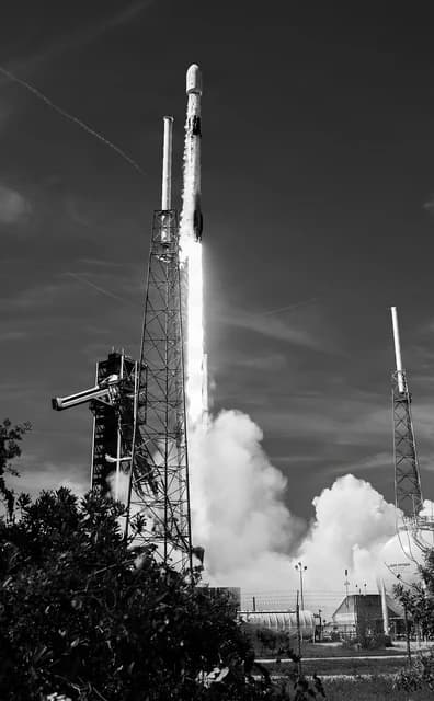 SpaceX Falcon 9 rocket lifting off with a trail of smoke and fire at Cape Canaveral.