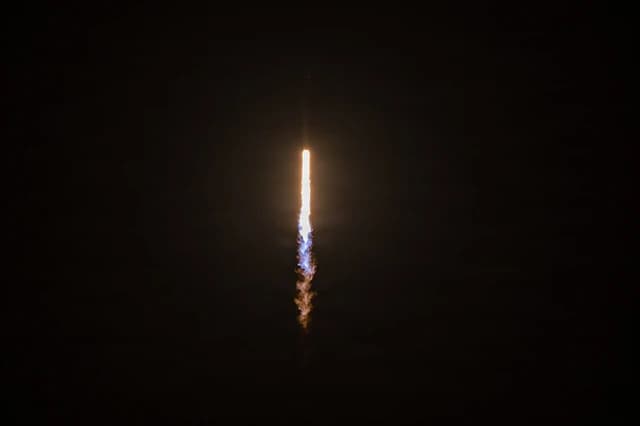 A rocket launches from Cape Canaveral Space Force Station, leaving a fiery trail.