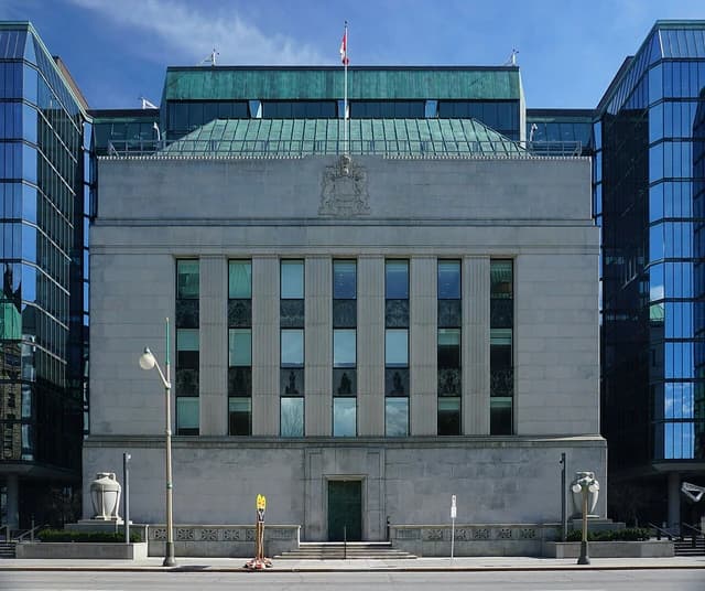 Facade of the Bank of Canada building, with a Canadian flag on the roof.