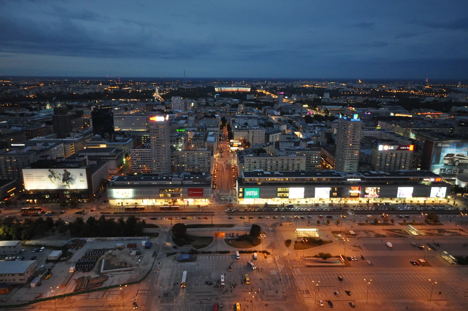 Aerial night view of Warsaw city center with illuminated buildings and streets.
