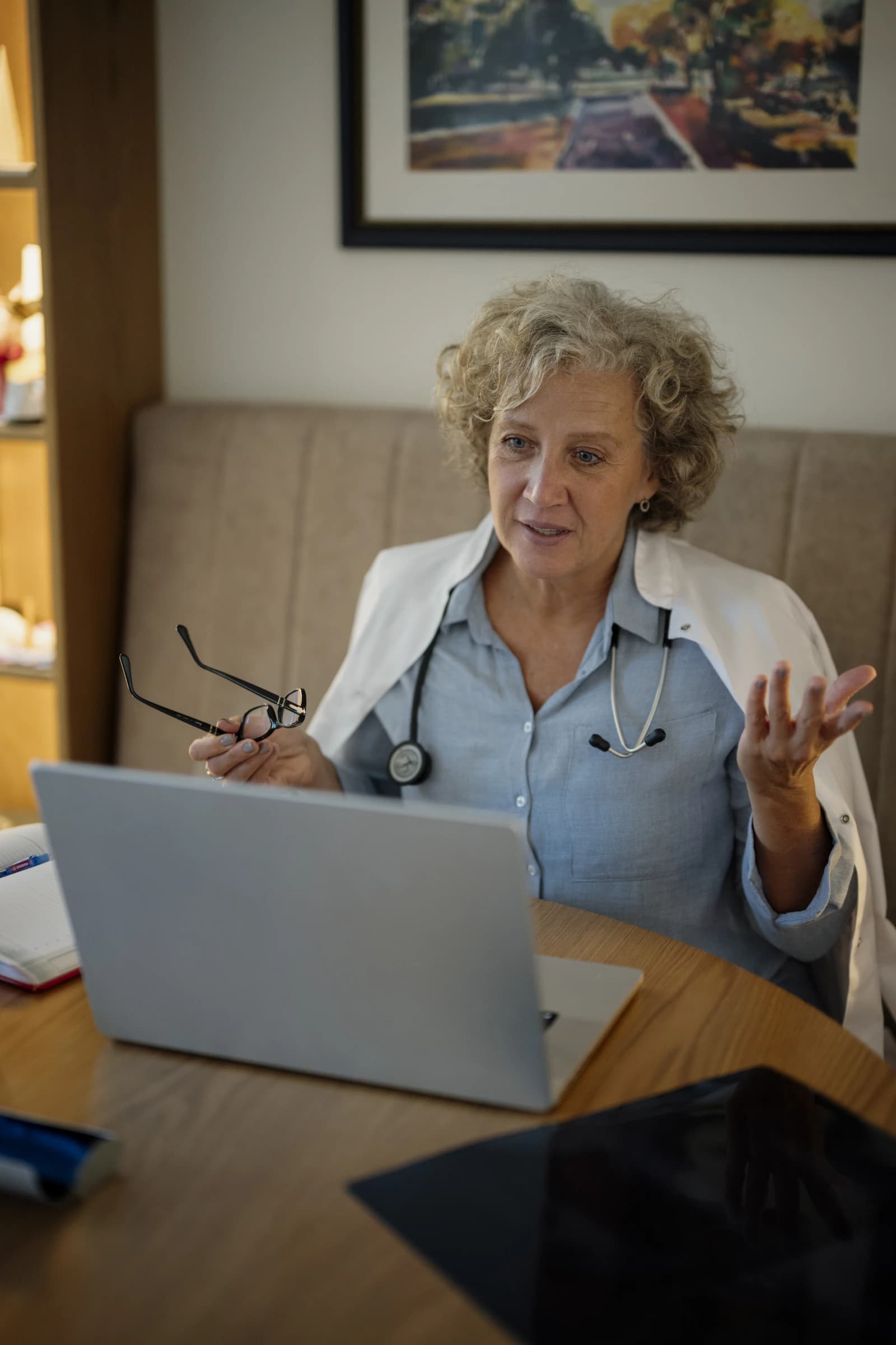 Female doctor talks to a patient on a laptop during a video consultation.