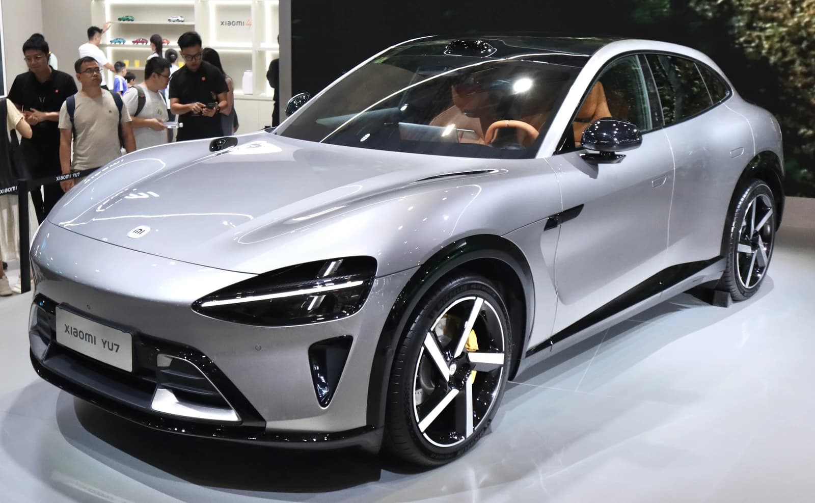Silver Xiaomi YU7 electric vehicle on display at an automotive show.