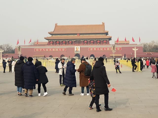 People gathered in Tiananmen Square, Beijing, with the Gate of Heavenly Peace in the background.