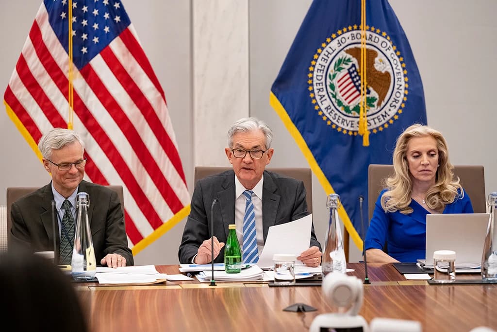 Jerome Powell, Chair of the Federal Reserve, speaking at a meeting table.
