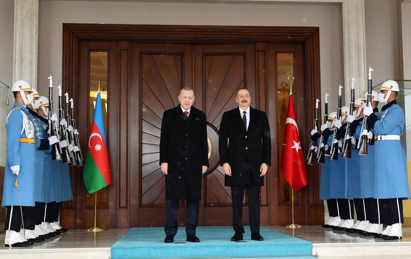Recep Tayyip Erdogan and Ilham Aliyev stand on a blue carpet with honor guards and flags.