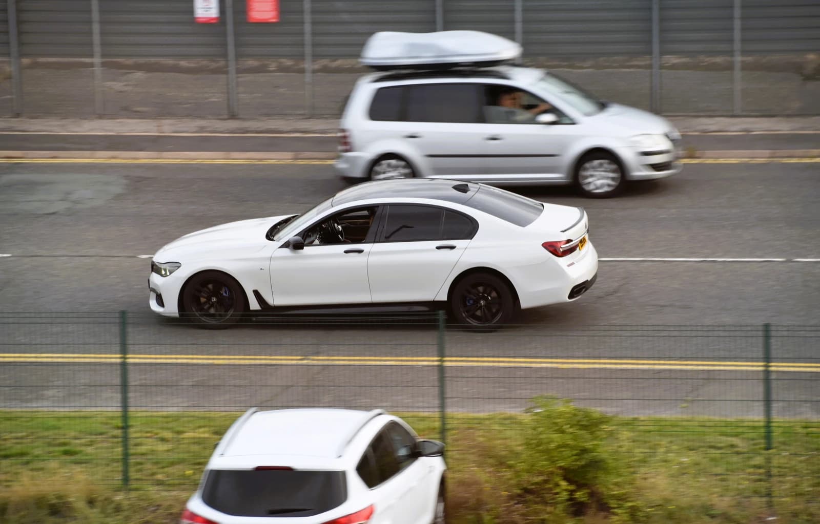 White BMW 7-Series (G11) 730d sedan driving on a road.