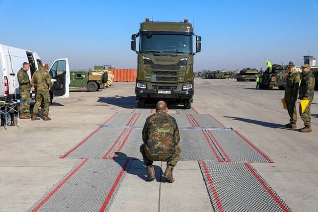 Bundeswehr personnel testing weight of heavy equipment transport system with a Scania truck.