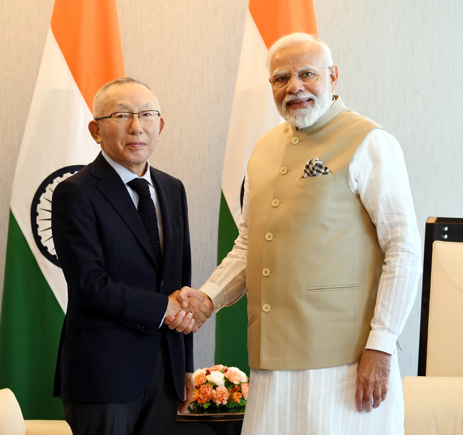 Tadashi Yanai, Chairman, President & CEO of UNIQLO, shakes hands with India's Prime Minister Narendra Modi.