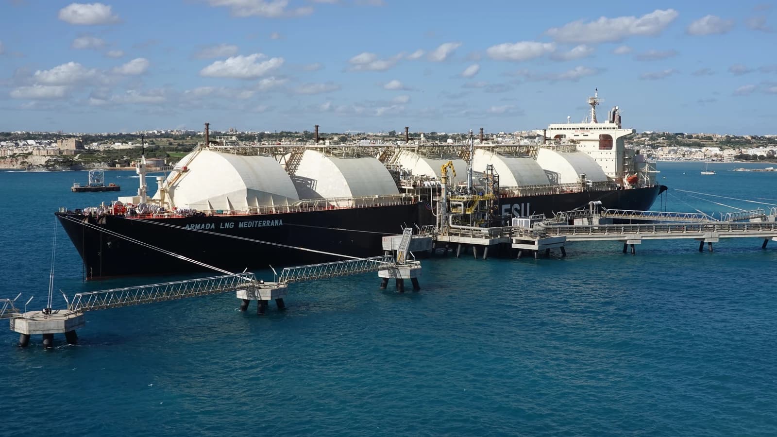 A large liquefied natural gas carrier ship moored at a coastal facility.