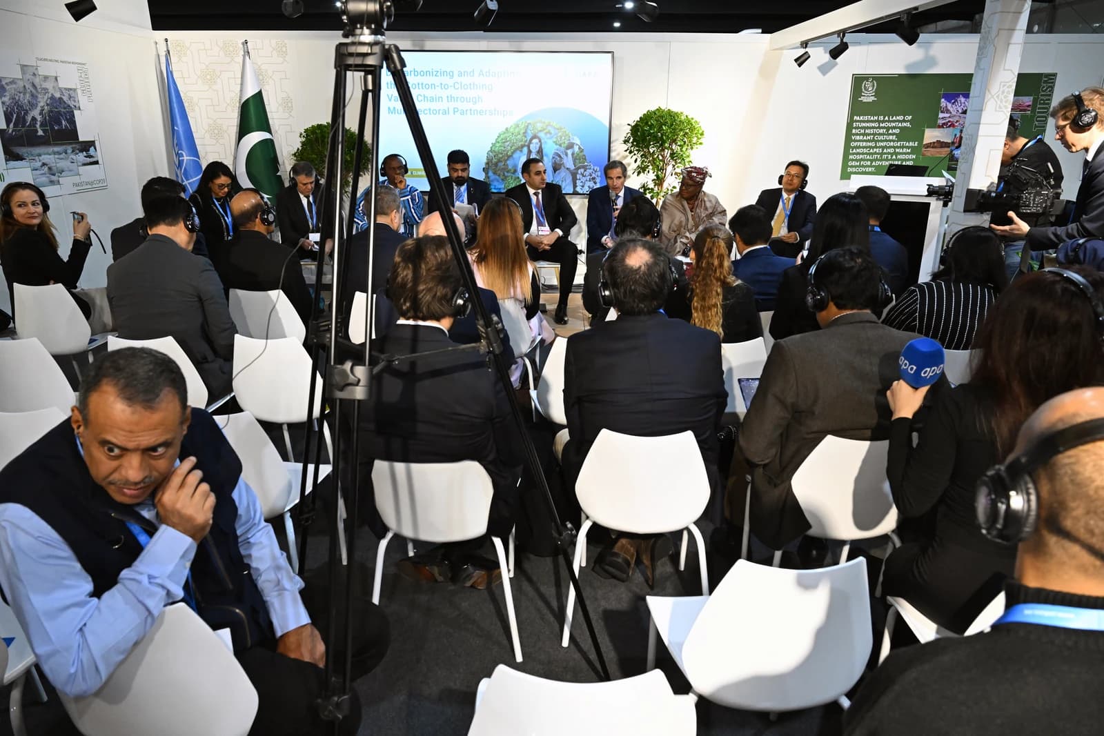 Panelists seated on a stage addressing an audience at a conference.