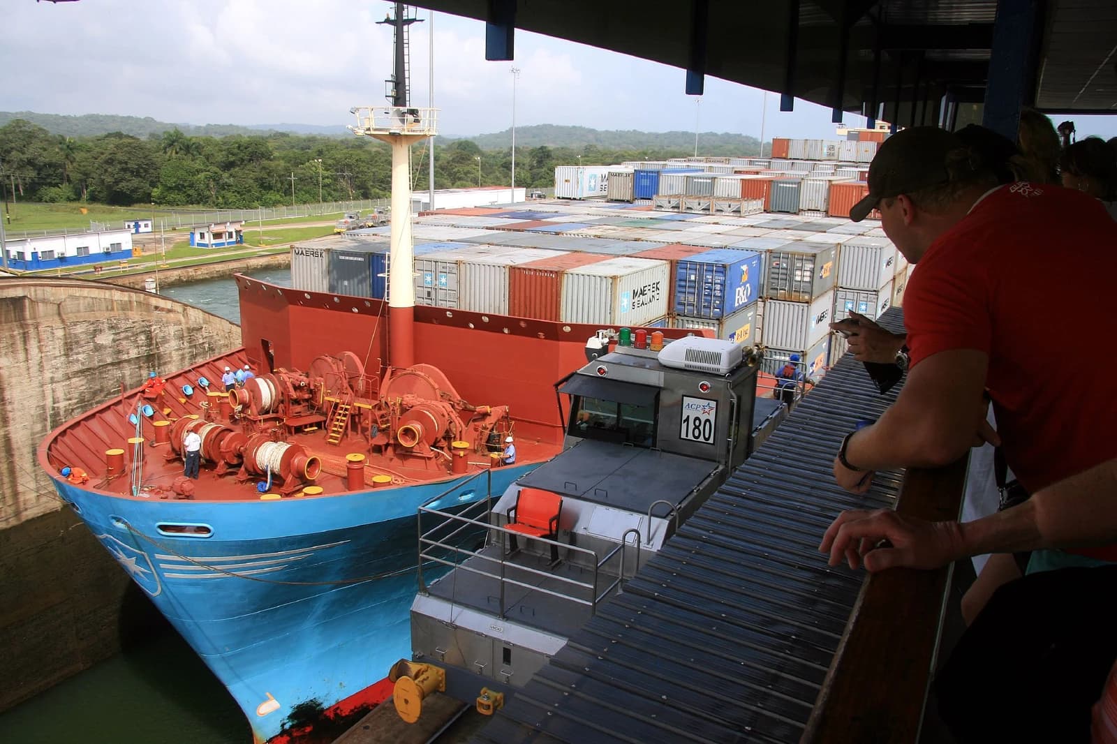 Container ship being guided through a lock in the Panama Canal system.