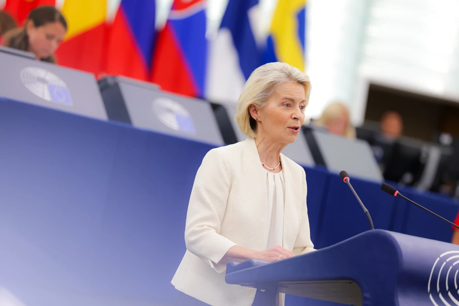 Ursula von der Leyen, President of the EC, speaking at a podium.