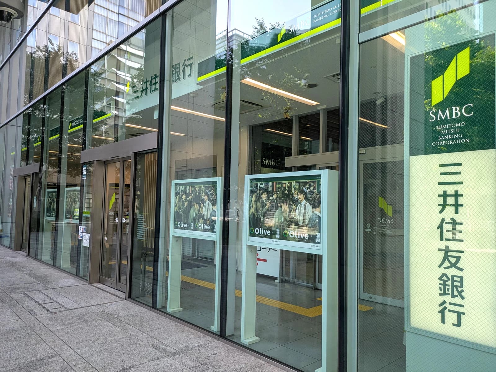 Exterior of a Sumitomo Mitsui Banking Corporation branch building with its logo visible.