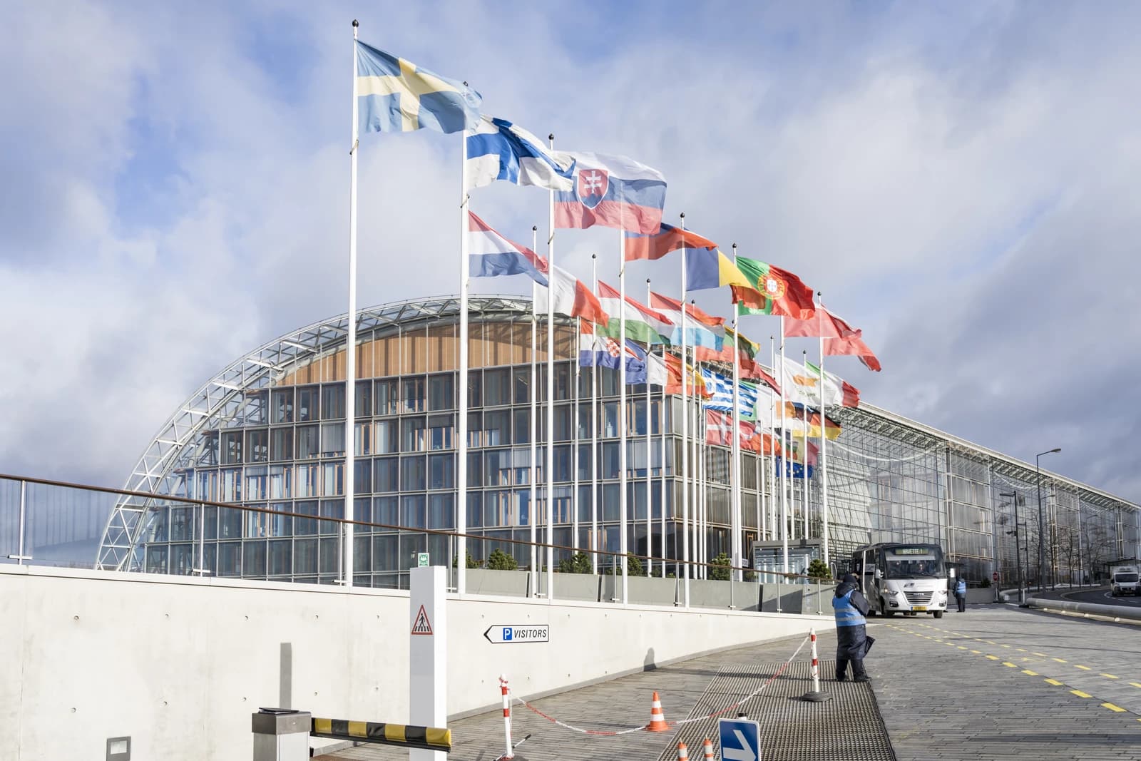 European Investment Bank Group Headquarters building with flags of European countries flying outside.
