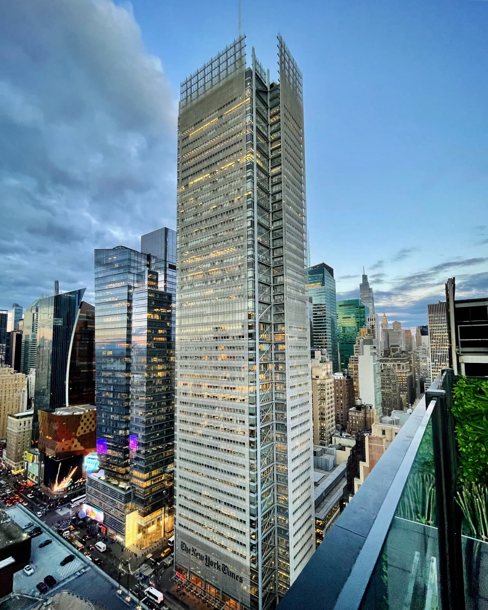 The New York Times Building illuminated at dusk in Midtown Manhattan skyline.