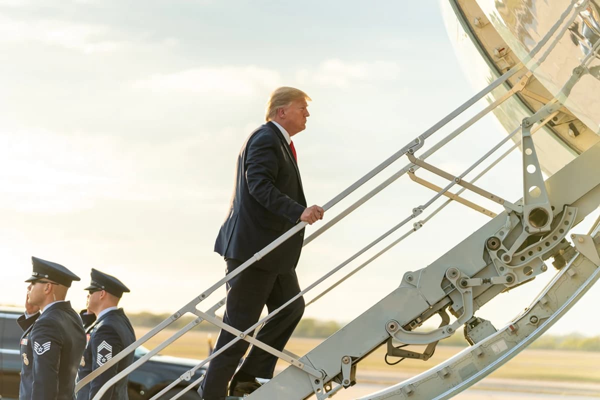 Donald Trump, former President of the United States, walking up stairs to a plane.