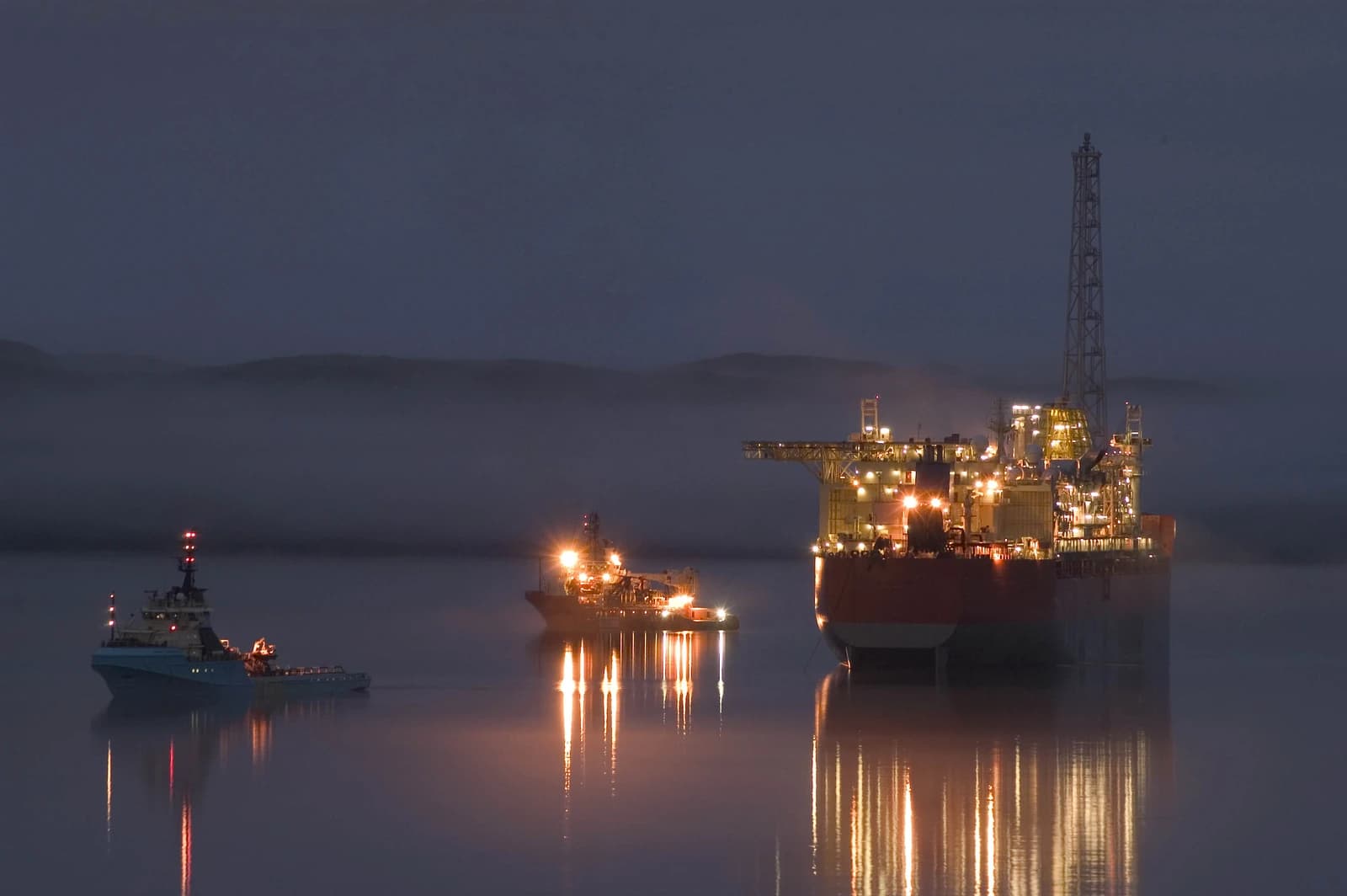 SeaRose FPSO offshore oil and gas production vessel illuminated at night with two support vessels nearby.