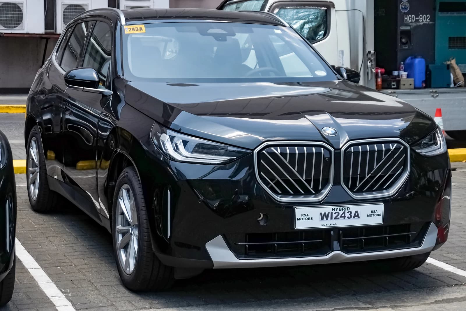 Black BMW X3 30e G45 SUV parked in an urban outdoor setting.