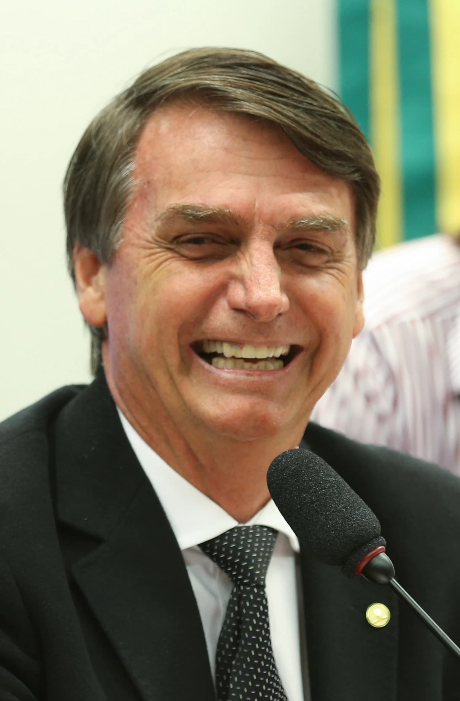 Jair Bolsonaro, then a federal deputy, smiling at the Brazilian Chamber of Deputies.