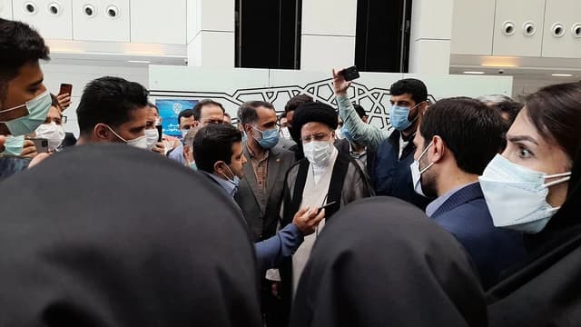 Ebrahim Raisi, former Iranian President, surrounded by people at Tehran Stock Exchange.