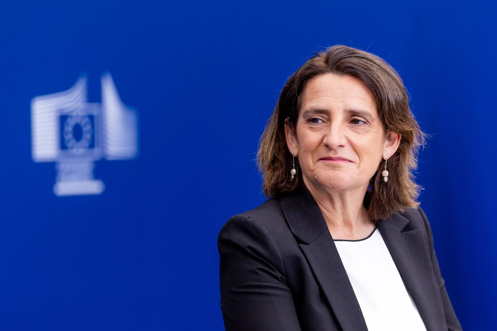 Teresa Ribera, Executive Vice-President of the European Commission, listening at a press point.