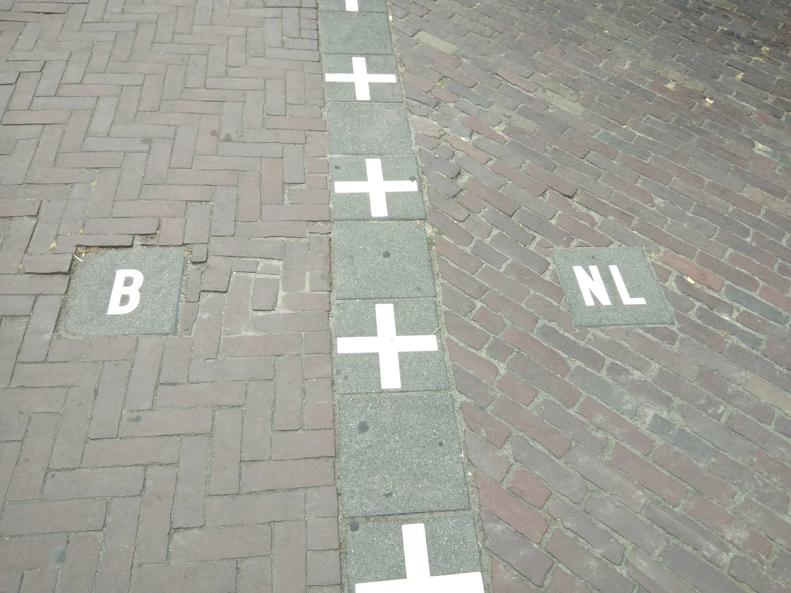 Belgium and Netherlands international border painted on a street in Baarle.
