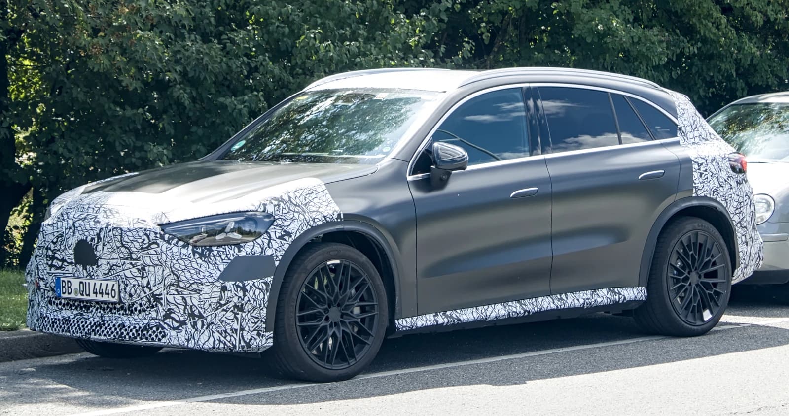 Mercedes-AMG GLC with EQ Technology, partially camouflaged, parked on a street.