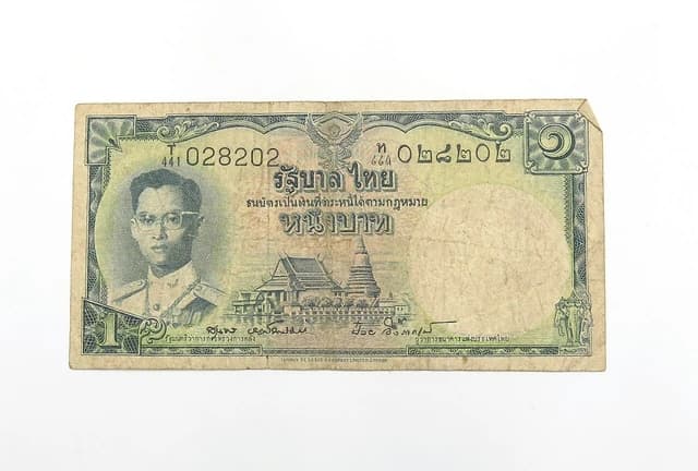 Close-up of an old Thai 1 Baht banknote on a white background.