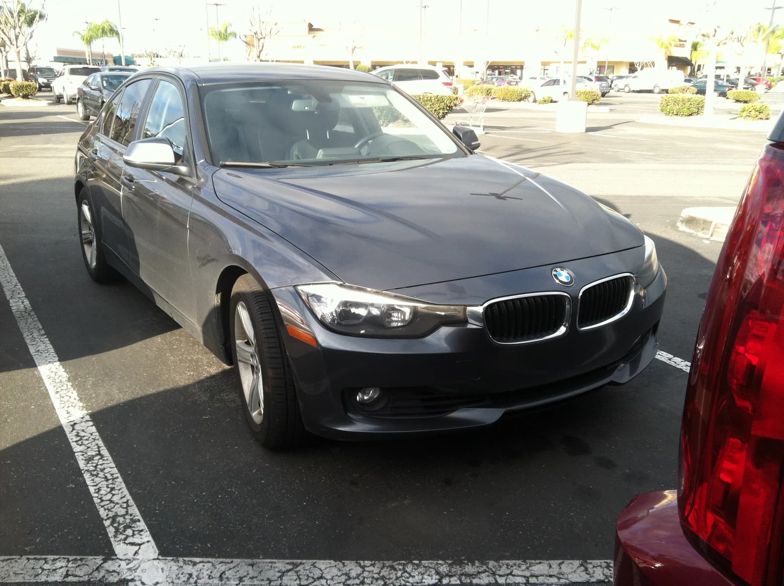 A grey BMW 3 Series sedan parked in an outdoor parking lot.