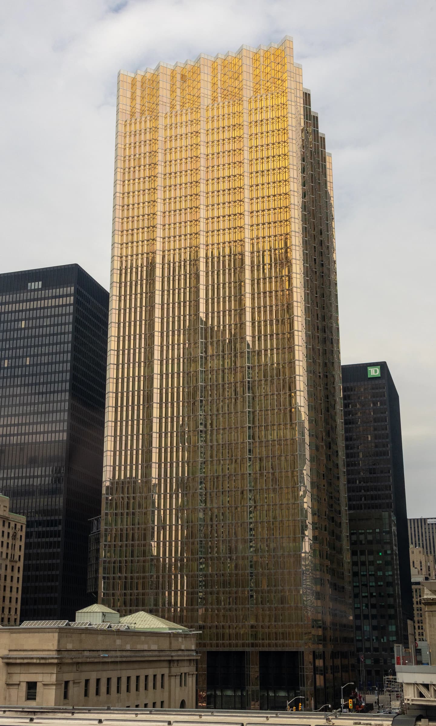 Royal Bank Plaza South Tower, a golden-clad skyscraper, stands tall against a cloudy sky.
