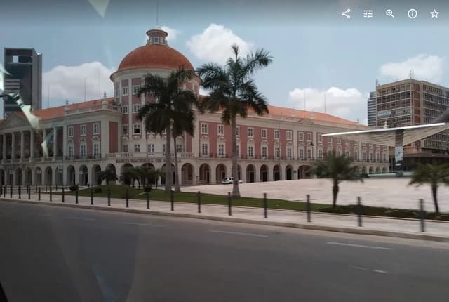 Exterior view of the National Bank of Angola building in Luanda, with palm trees.