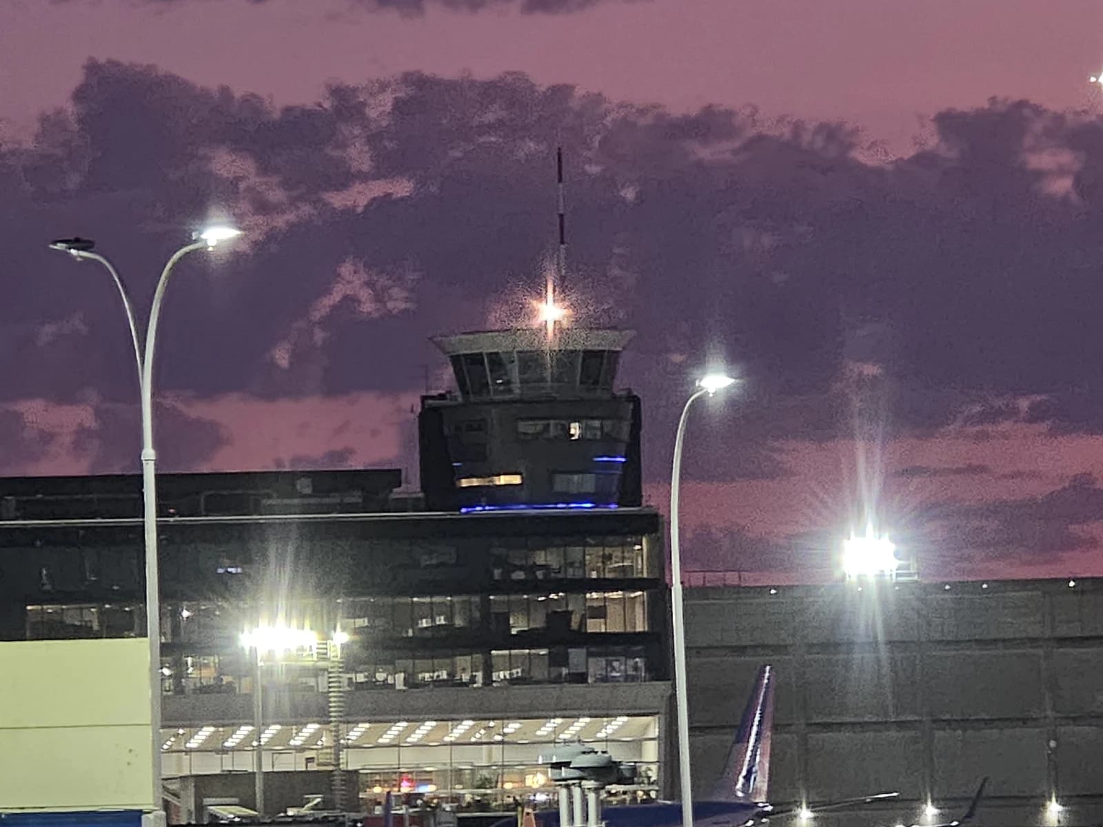Control tower of Aeroparque Jorge Newbery in Buenos Aires against a magenta sunrise.